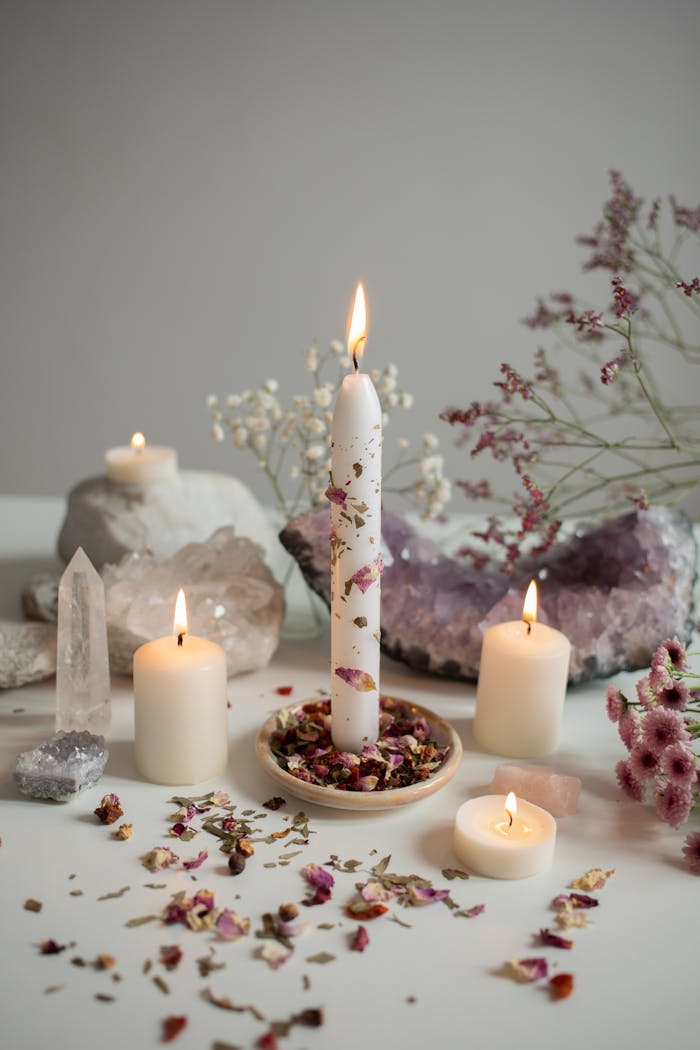 A serene arrangement of candles, crystals, and dried flowers creates a calming atmosphere.